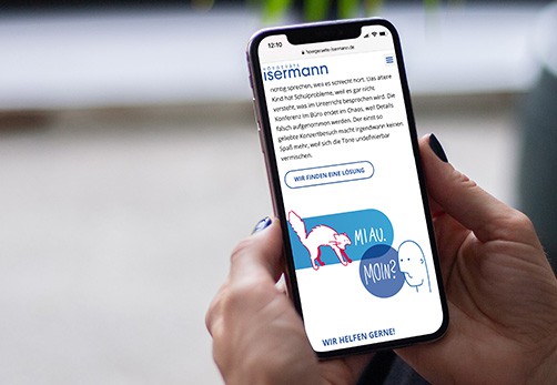 In diesem Bild sieht man ein Smartphone aus dessen Display man die Webseite der Firma Isermann Hörgeräte abgebildet ist.